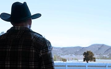 Home internet customer with cowboy hat looking out at the mountains